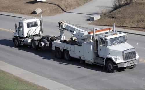 Heavy truck being towed by another heavy truck