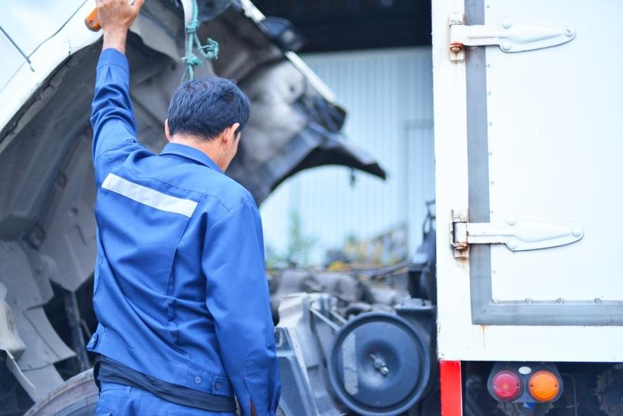 Truck driver inspecting his broken down engine